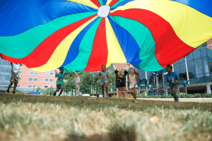 Featured Image for community outreach kids under parachute