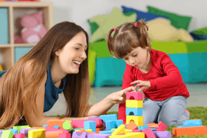 Featured Image for babysitter and girl with blocks