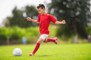 Featured Image for boy playing soccer in red shirt