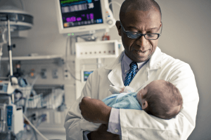 Featured Image for dr forbes holding baby in picu