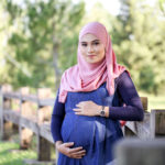 Tips to prepare mentally for pregnancy – and beyond Young pregnant women with blue dress holding belly
