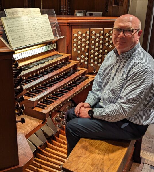 Dr. Steven Kuerbitz sits at the pipe organ in the Church of the Covenant