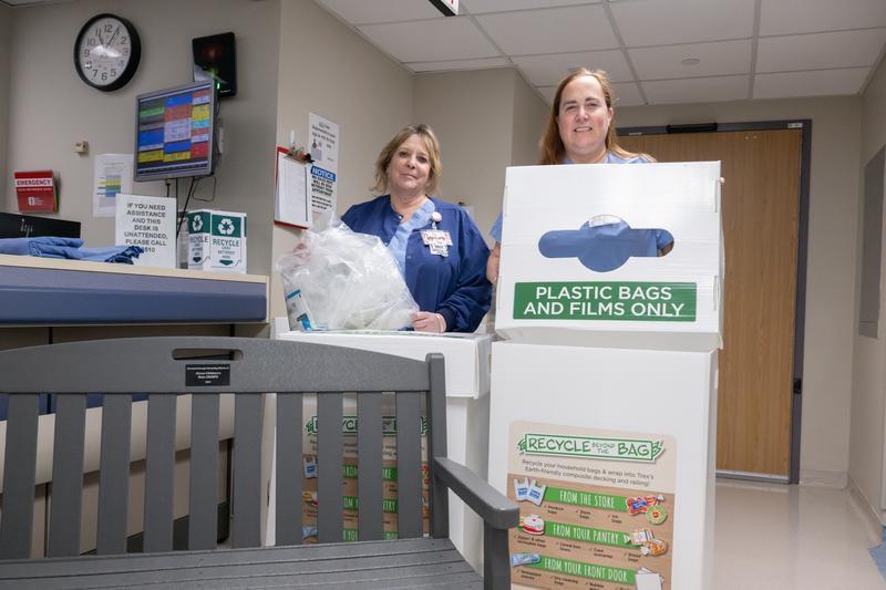 Bonnie Humiston and Debi Russell with the recycled bench and collection bins