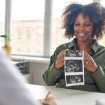 Everything you need to know about pregnancy ultrasounds Getty Image - mom with ultrasound images